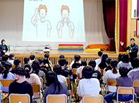 学校の体育館で総合的な学習の時間に小学生とともにノーマライゼーションを考える授業の画像